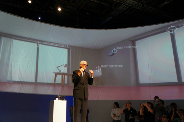 2014年9月に開催されたダイソン 360 Eyeの発表会の模様。創業者であるジェームズ・ダイソン氏の背後のスクリーンには、カメラで部屋の特徴点を捉えるダイソン独自の「360°ビジョンシステム」のイメージが映し出されている