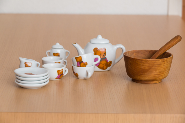 熊のイラストのついた愛らしいティーポットとティーカップなどのセットは、小さいけれど本物の陶器。右は息子が愛用した桜の木のお椀とスプーン