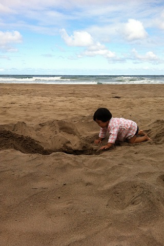 子どもは砂遊びが大好き！　須賀さんは、海水や日焼け対策にハワイのユーズドショップで子ども用ローブ(1ドル)を現地購入